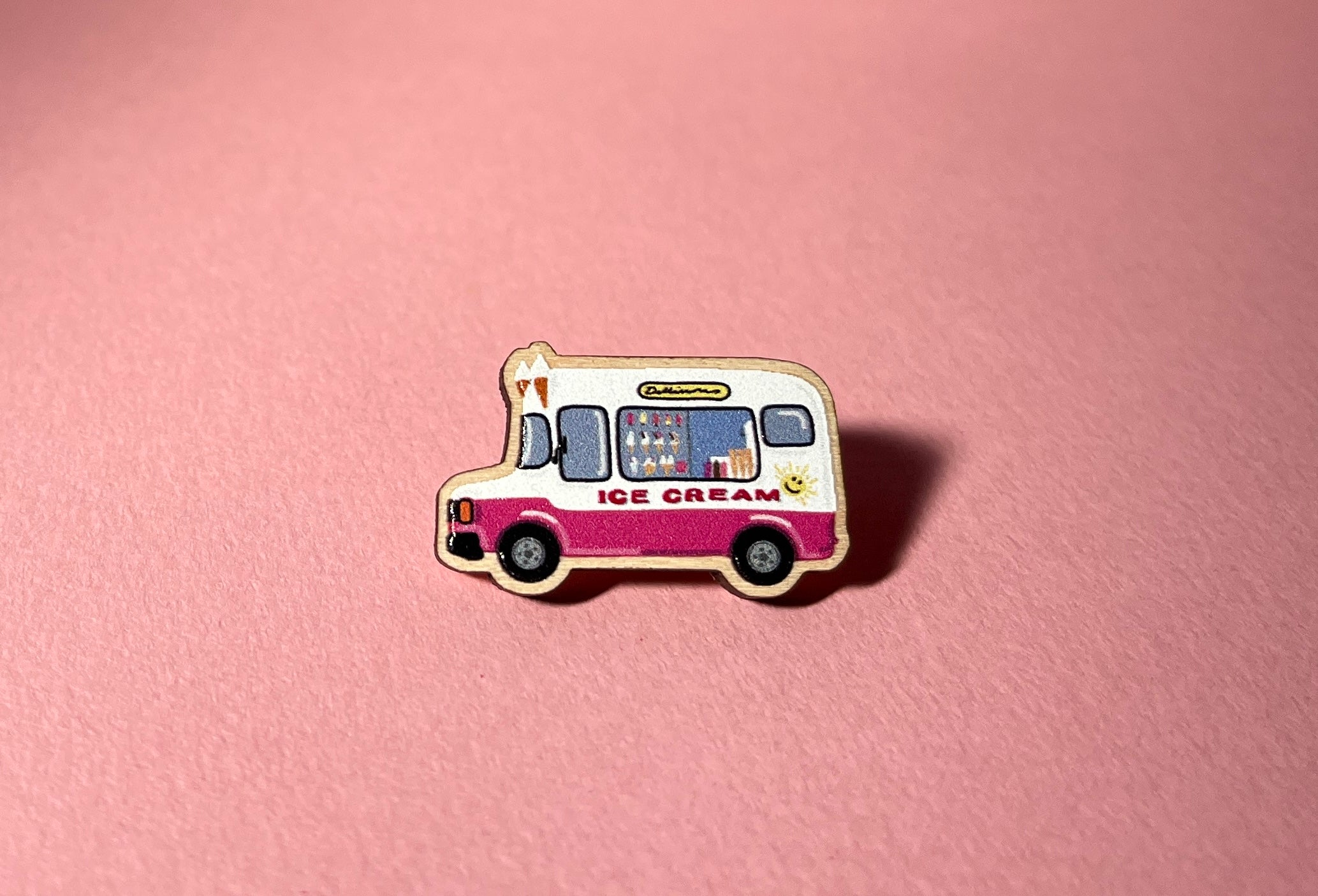 Pin of an ice cream truck on a pink background
