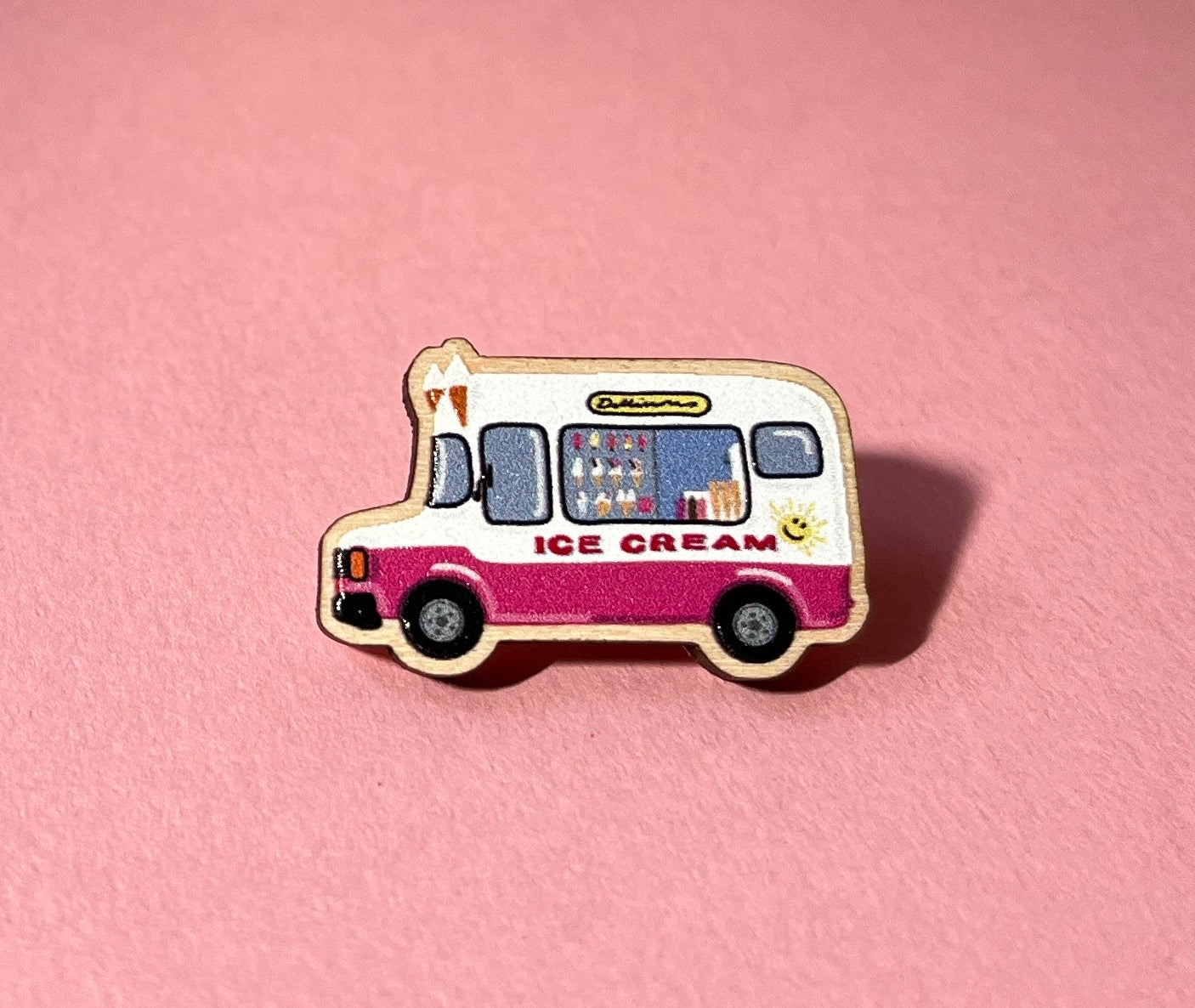 Pin of an ice cream truck on a pink background
