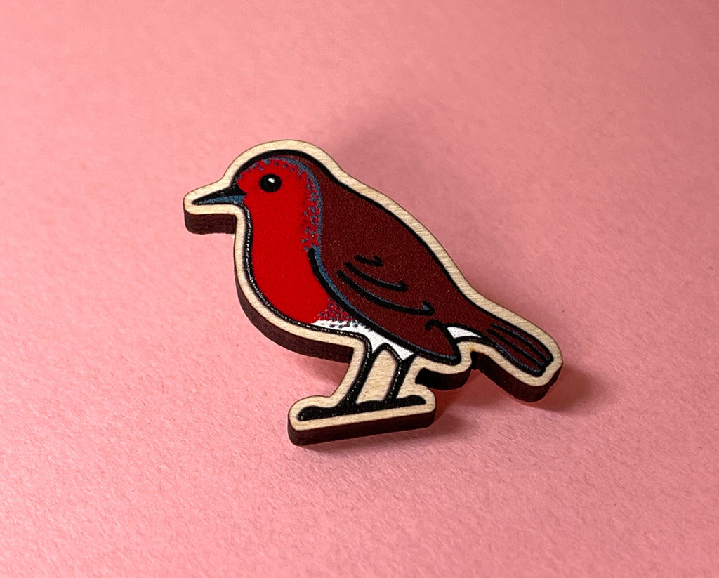 Bird-shaped wooden pin on a pink background