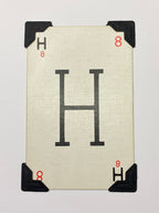 A white card with a black letter H printed on it. The card has black corner protectors.